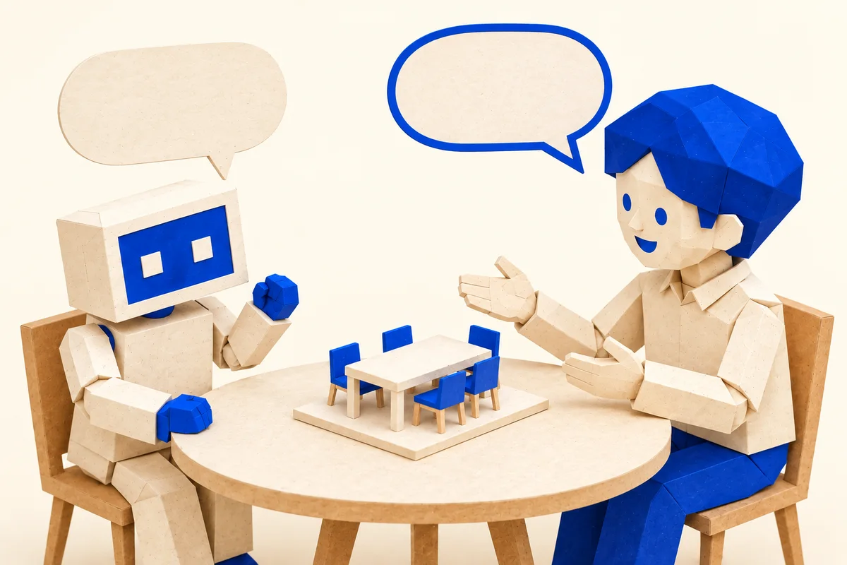 会議室の模型を前に人が説明し、AIマスコットがお客さん役として質問する紙細工の図